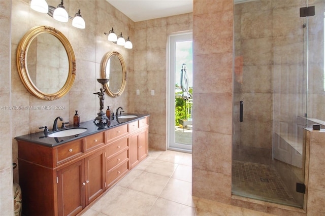 bathroom with a stall shower, tile patterned floors, and a sink