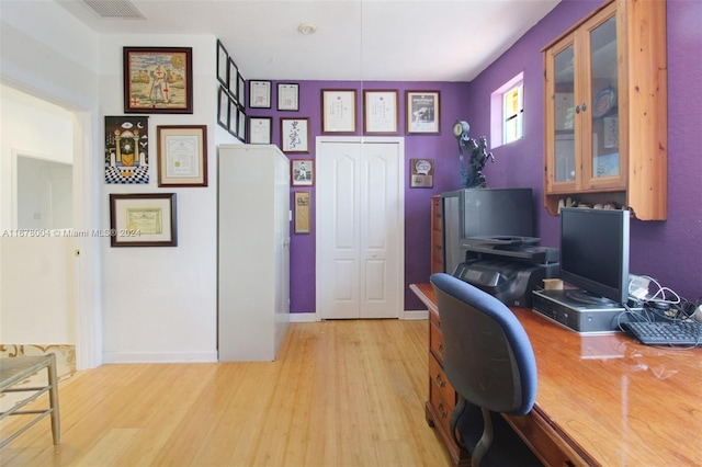 home office with light hardwood / wood-style floors