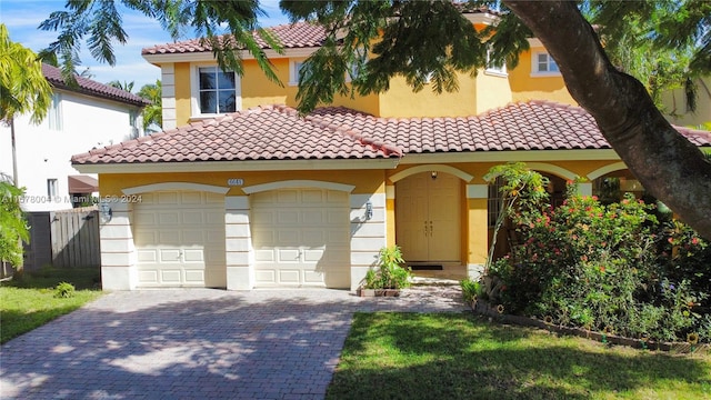 mediterranean / spanish-style home with a garage and a front lawn