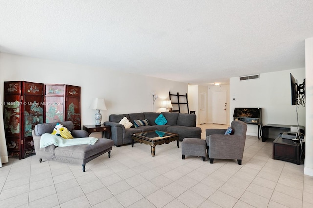 tiled living room featuring a textured ceiling