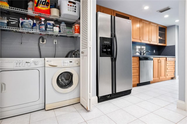 washroom with washing machine and dryer and light tile patterned floors