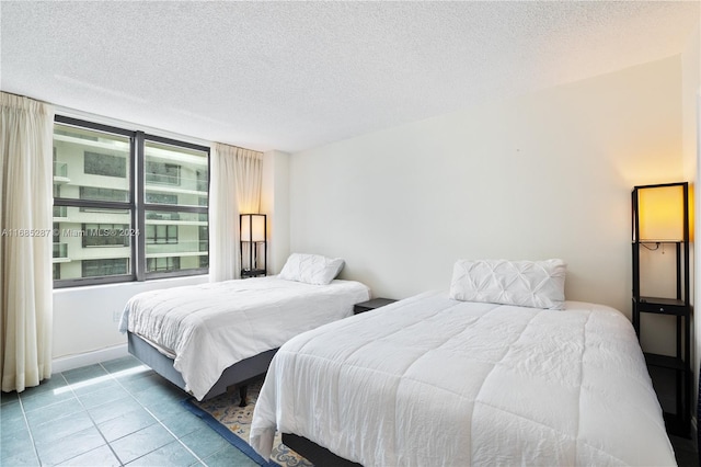 bedroom with light tile patterned flooring and a textured ceiling