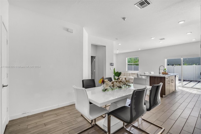 dining room with sink and light hardwood / wood-style floors