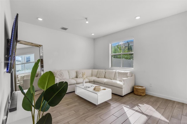 living room with plenty of natural light and light hardwood / wood-style flooring