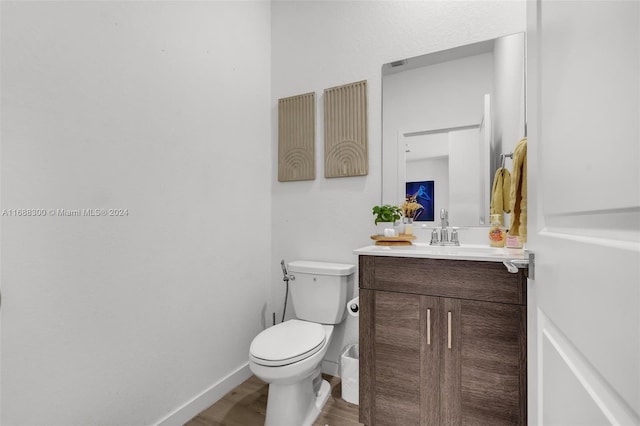 bathroom featuring hardwood / wood-style floors, vanity, and toilet