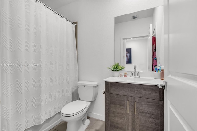 bathroom with tile patterned flooring, vanity, and toilet