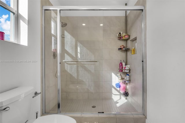 bathroom with toilet and a shower with shower door