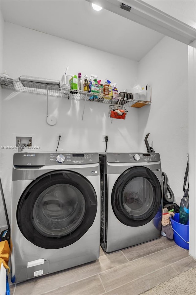 laundry area with light wood-type flooring and washing machine and dryer