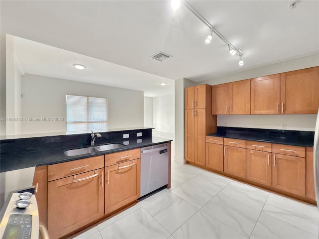 kitchen with rail lighting, dishwasher, and sink