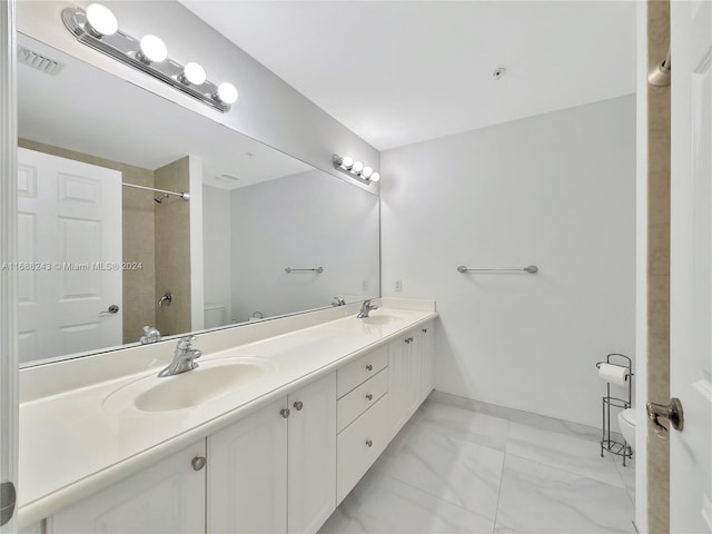 bathroom featuring vanity, toilet, and tiled shower