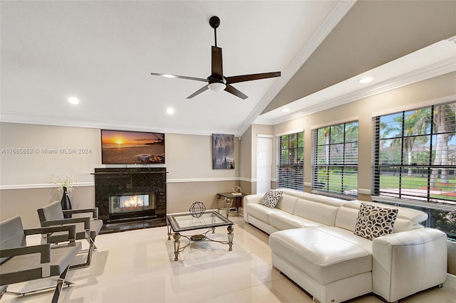 tiled living room with ceiling fan, a premium fireplace, ornamental molding, and vaulted ceiling