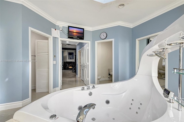 bathroom with a tub, crown molding, and toilet