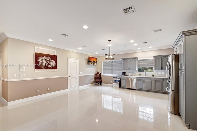 kitchen featuring appliances with stainless steel finishes, decorative light fixtures, ornamental molding, and light tile patterned flooring