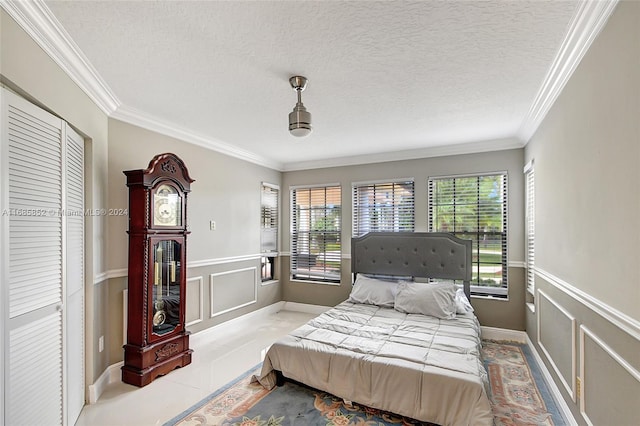 bedroom with a textured ceiling, a closet, ornamental molding, and ceiling fan