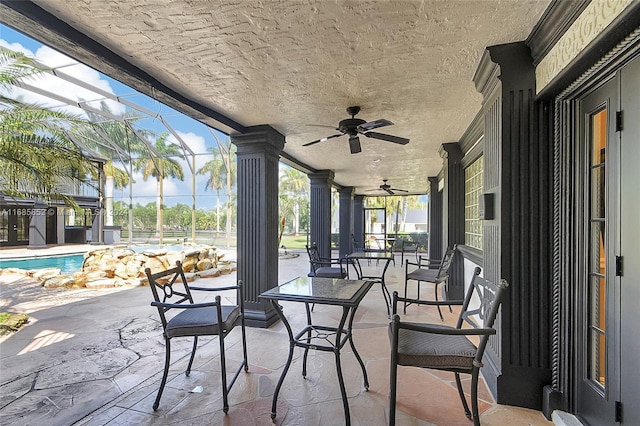 view of patio featuring glass enclosure and ceiling fan