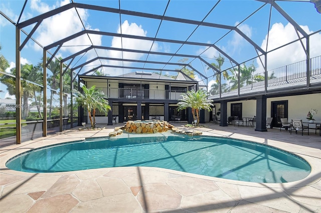 view of pool with glass enclosure and a patio