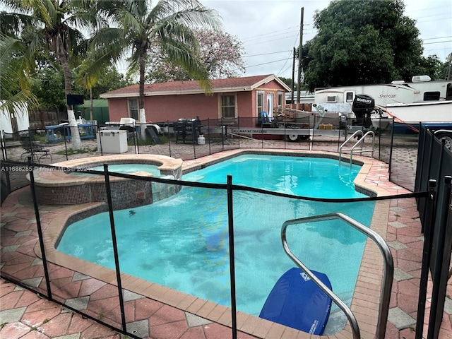 view of swimming pool featuring a patio area and an in ground hot tub