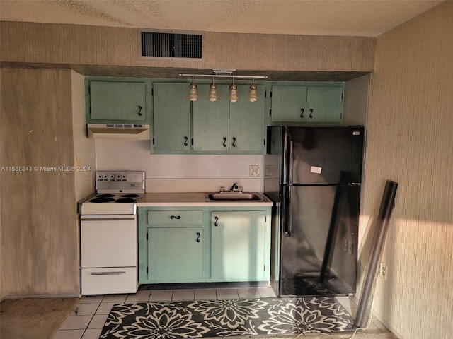 kitchen featuring sink, light tile patterned floors, ventilation hood, black refrigerator, and electric range