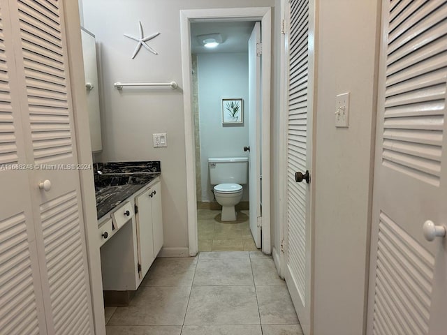 bathroom with tile patterned flooring, vanity, and toilet