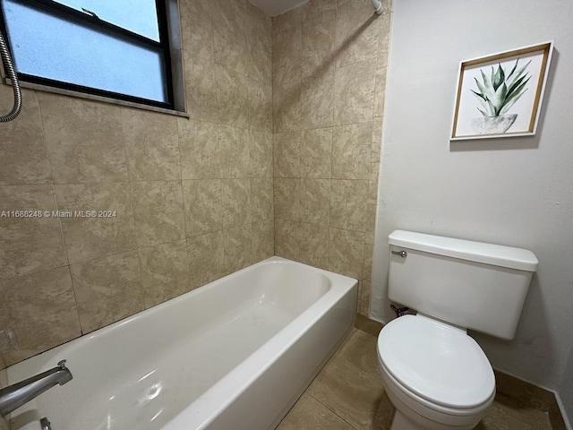 bathroom with tile patterned floors, tiled shower / bath combo, and toilet