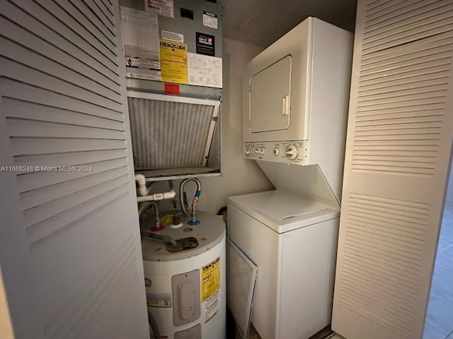 laundry room with stacked washer / drying machine and water heater