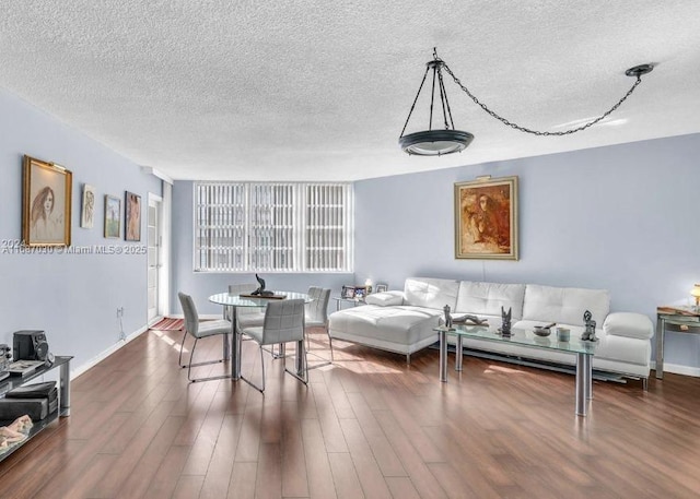 living room featuring dark wood-type flooring and a textured ceiling