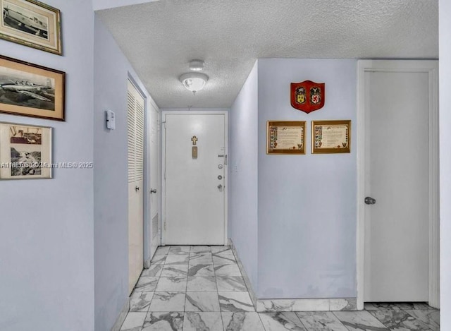 hall featuring a textured ceiling