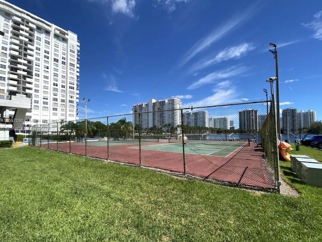 view of tennis court with a lawn