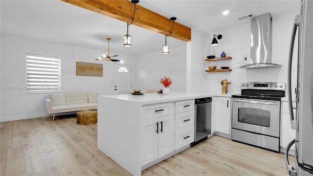 kitchen featuring range hood, appliances with stainless steel finishes, decorative light fixtures, and white cabinets