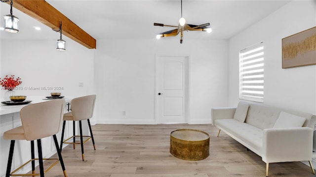 living room with beamed ceiling, a chandelier, and light hardwood / wood-style flooring