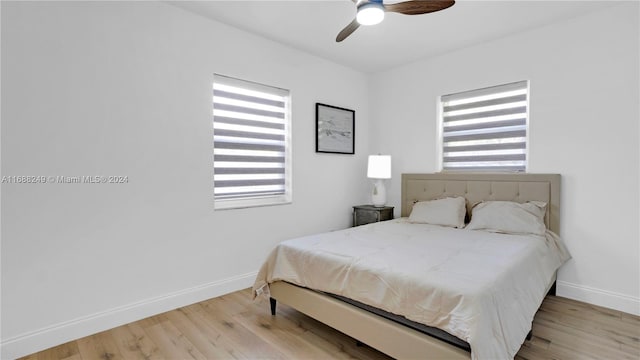 bedroom with multiple windows, ceiling fan, and light hardwood / wood-style flooring