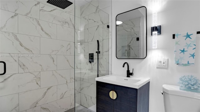 bathroom featuring vanity, toilet, and a shower with door