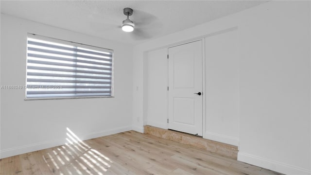 unfurnished room featuring a textured ceiling, light hardwood / wood-style flooring, and ceiling fan