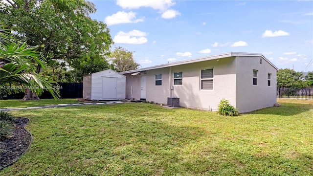 back of house featuring a storage unit and a yard