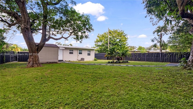 view of yard with central AC and a storage shed