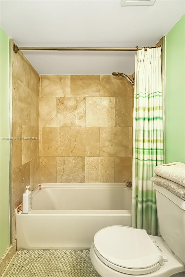 bathroom with toilet, tile patterned flooring, and shower / bathtub combination with curtain