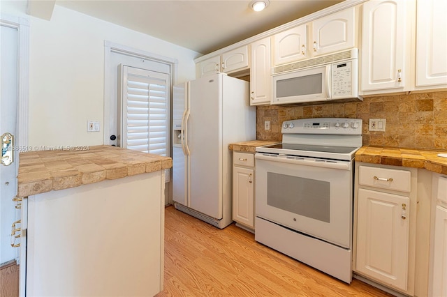 kitchen featuring white cabinetry, tasteful backsplash, light hardwood / wood-style flooring, tile countertops, and white appliances