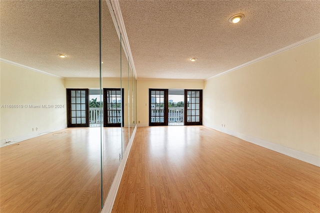 455 Paradise Isle Blvd Unit 402, Hallandale Beach, FL 33009 - empty room featuring a textured ceiling, light wood-type flooring, ornamental molding, and baseboards