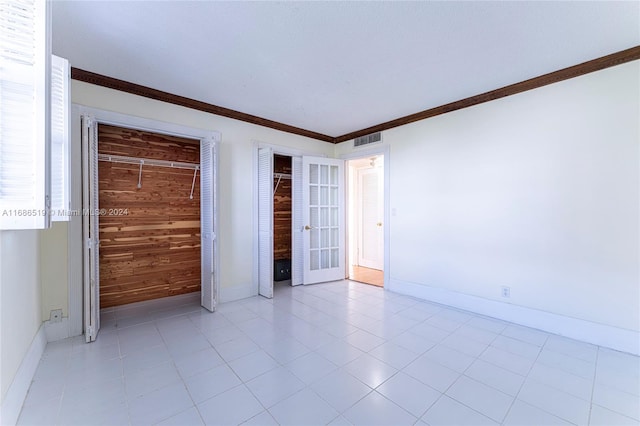 spare room featuring wooden walls and crown molding