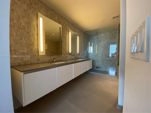 bathroom featuring tasteful backsplash, vanity, concrete floors, and a shower with shower door