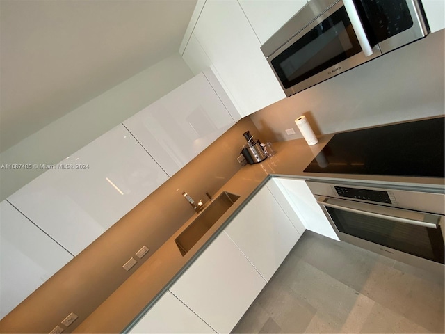 kitchen with white cabinetry, appliances with stainless steel finishes, and sink