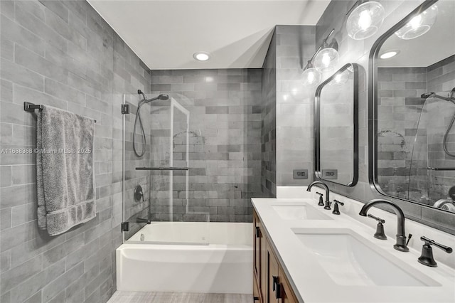 bathroom with tile walls, tiled shower / bath combo, and vanity