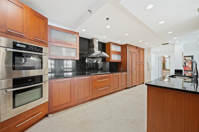 10175 Collins Ave Unit 1003, Bal Harbour, FL 33154 - kitchen with stainless steel double oven, wall chimney range hood, black electric stovetop, a sink, and backsplash