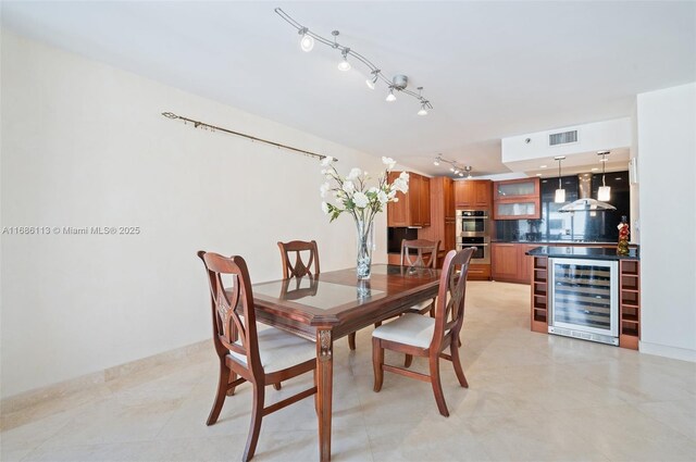 10175 Collins Ave Unit 1003, Bal Harbour, FL 33154 - dining area with wine cooler, rail lighting, light tile patterned floors, and baseboards