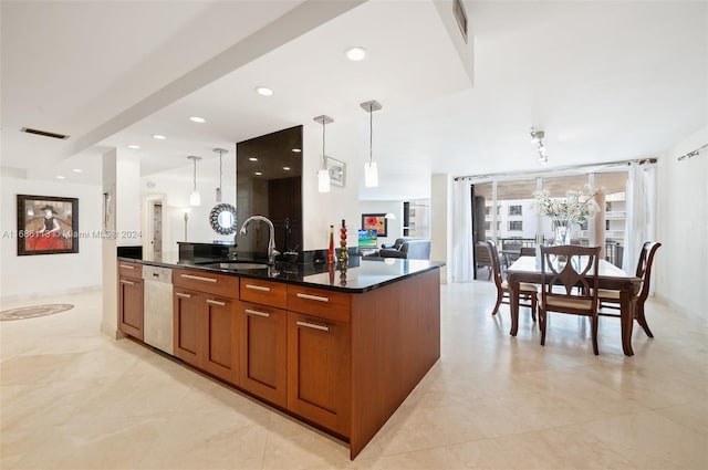 kitchen with a kitchen island with sink, white dishwasher, sink, and decorative light fixtures