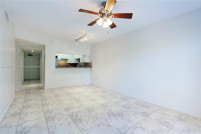 unfurnished living room featuring track lighting and ceiling fan