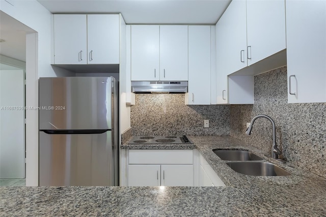 kitchen with sink, stainless steel fridge, and white cabinets