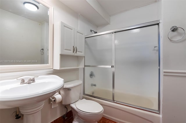 bathroom with combined bath / shower with glass door and toilet