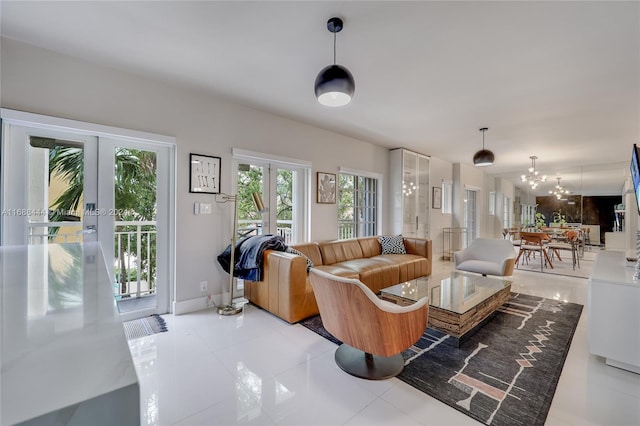 tiled living room featuring french doors and a notable chandelier