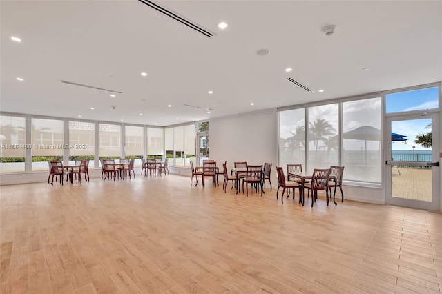 dining room with expansive windows, light hardwood / wood-style floors, and plenty of natural light